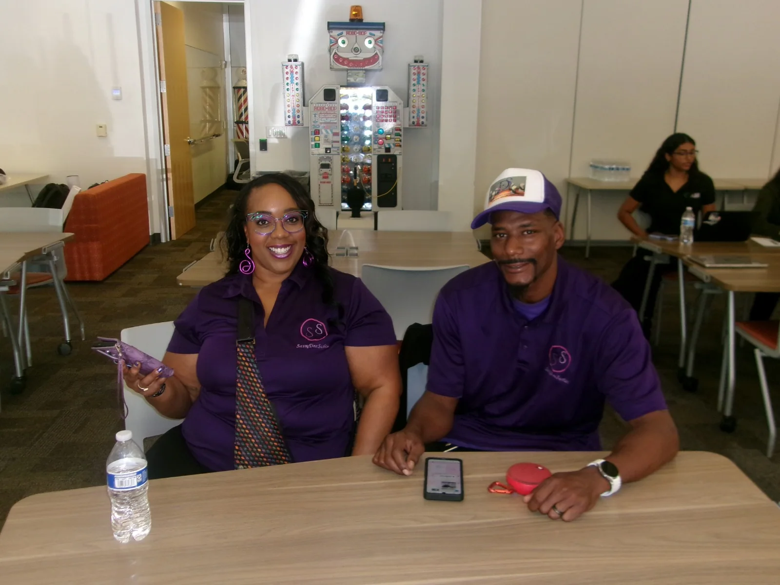 Two business owners in purple shirts seated at a past AMI event